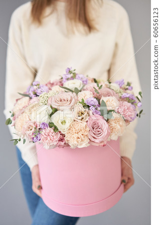 European floral shop. Floral bunch in round box. Bouquet of beautiful Mixed flowers in woman hand. Excellent garden flowers in the arrangement , the work of a professional florist. European floral shop. Floral bunch in round box. Bouquet of beautiful Mixed flowers in woman hand. Excellent garden flowers in the arrangement , the work of a professional florist. 60656123