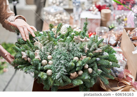 A woman decorates a Christmas arrangement. Master class on making decorative ornaments. Christmas decor with their own hands. The new year celebration. Flower shop 60656163