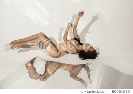 Young and stylish modern ballet dancer on white background with mirrors 60661680