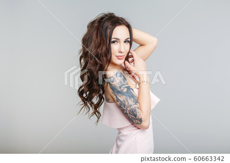 Beautiful young woman with stylish tattoo on hand Beautiful young woman with stylish tattoo on hand 60663342
