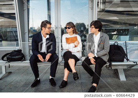 Two businessmen and a secretary discuss an important issue outside. 60664429