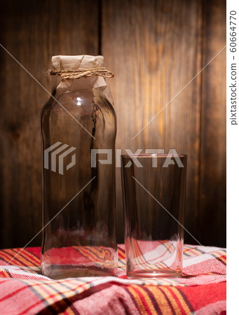 Still life of an empty glass bottle and glass Still life of an empty glass bottle and glass 60664770