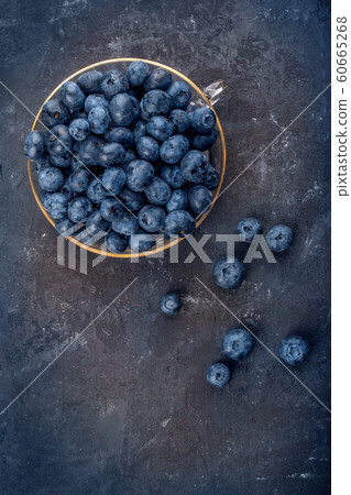 Fresh blueberries in a glass bowl on dark background Fresh blueberries in a glass bowl on dark background 60665268