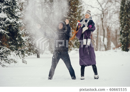 Little girl with parents in a winter park Little girl with parents in a winter park 60665535