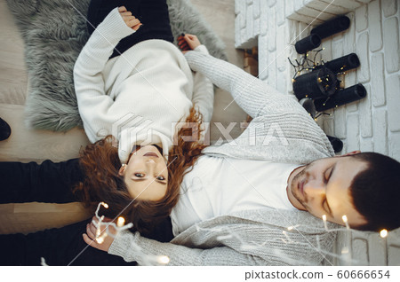 Cute couple at home in a warm sweaters Cute couple at home in a warm sweaters 60666654