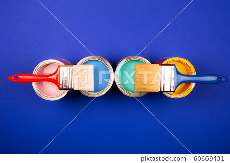 Four open cans of paint with brushes on bright background. 60669431