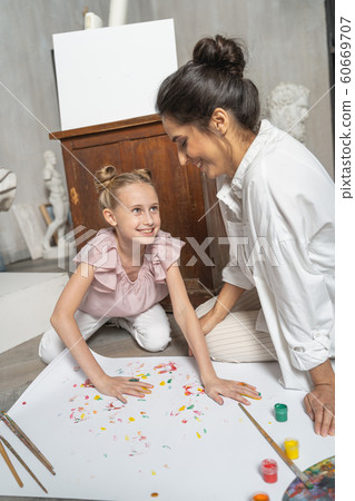 Nice little girl making nice picture with painted coloured palms 60669707