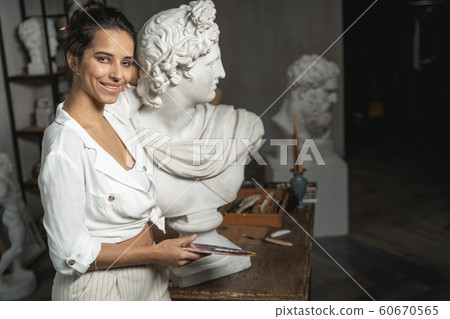 Beautiful female artist is posing near monument Beautiful female artist is posing near monument 60670565