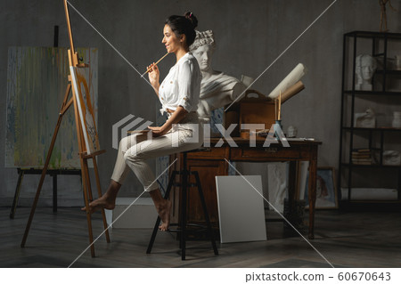Smiling young female artist thinking during working process Smiling young female artist thinking during working process 60670643