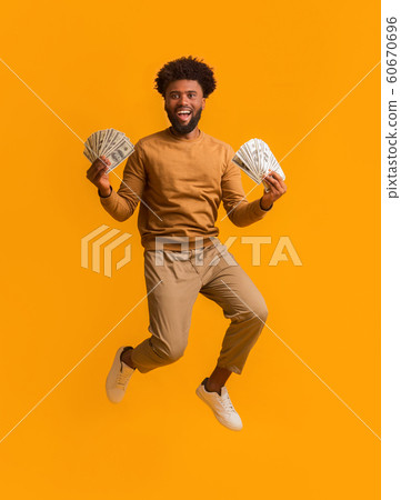 Super happy afro guy celebrating victory, holding lot of money 60670696