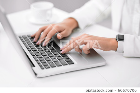 Unrecognizable latin girl working on her laptop 60670706