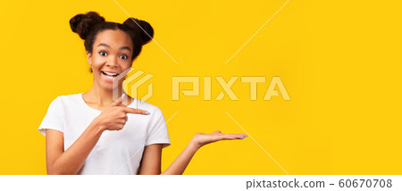 Happy african girl pointing with finger at copy space 60670708
