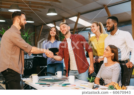 Chief designer shaking hands with customer in office 60670943