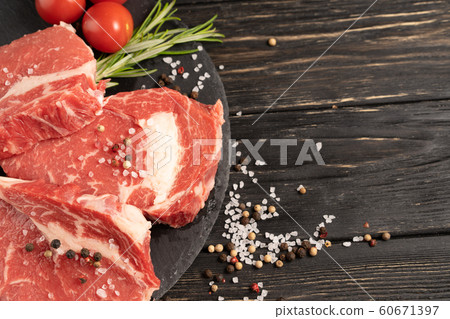 Three pieces of juicy raw beef on a stone cutting Three pieces of juicy raw beef on a stone cutting 60671397
