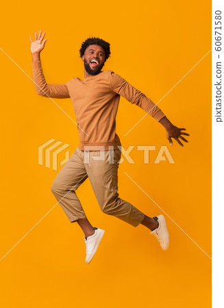 Funny laughing afro guy jumping in the air 60671580