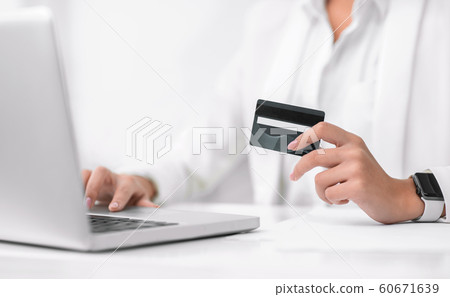 Closeup of girl making purchases using laptop computer 60671639