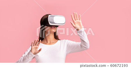 Young Lady In VR Glasses Standing Over Pink Studio Background Young Lady In VR Glasses Standing Over Pink Studio Background 60672193