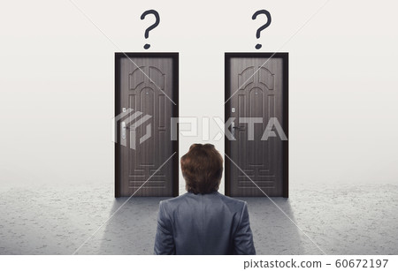 Confused man in suit looking at two similar doors Confused man in suit looking at two similar doors 60672197