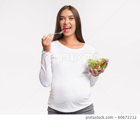 Happy Pregnant Woman Eating Vegetable Salad, Studio Shot Happy Pregnant Woman Eating Vegetable Salad, Studio Shot 60672212