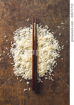 Uncooked indian long rice and chopsticks. 60672743