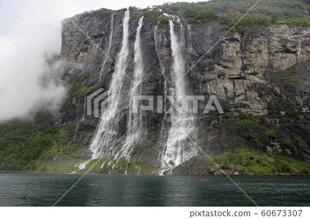 Kayak explorers at Seven Sisters waterfalls, Geiranger Fjord in Norway Kayak explorers at Seven Sisters waterfalls, Geiranger Fjord in Norway 60673307