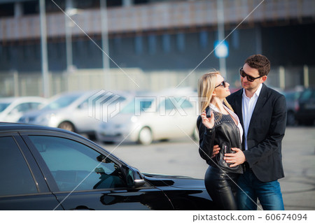 Happy couple buy new modern black car Happy couple buy new modern black car 60674094