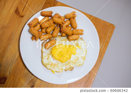 Fried Egg Sausage on a white plate on a wooden 60686342