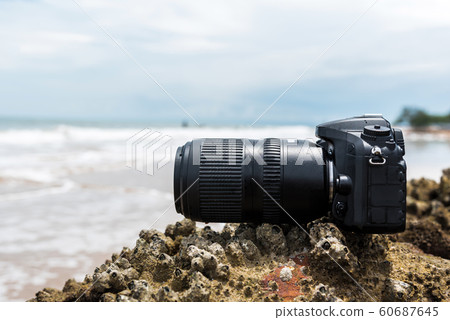 DSLR camera on stone beach wet from water sea wave DSLR camera on stone beach wet from water sea wave 60687645