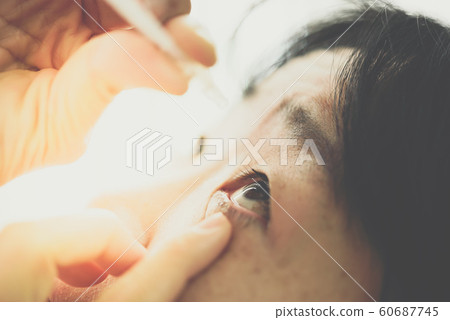 Woman use eye drop, artificial tears to the eye Woman use eye drop, artificial tears to the eye 60687745