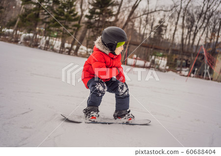 Little cute boy snowboarding. Activities for children in winter. Children's winter sport. Lifestyle 60688404