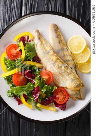 Fried zander fillet served with fresh salad 60691363