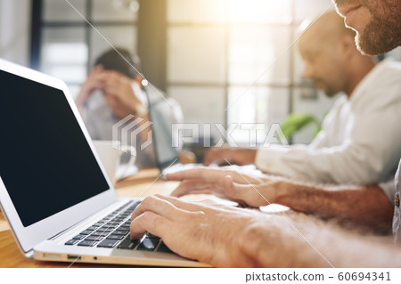 Bearded businessman working on laptop 60694341