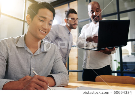 Smiling entrepreneur filling document 60694384