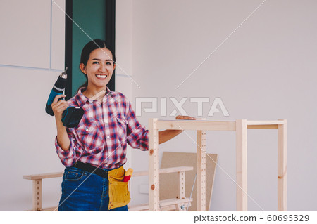 woman worker in the carpenter workroom. woman worker in the carpenter workroom. 60695329