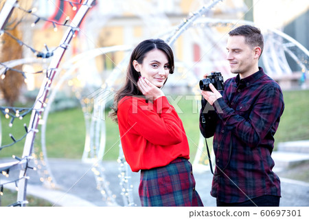 Happy couple taking photos of each other outdoors Happy couple taking photos of each other outdoors 60697301