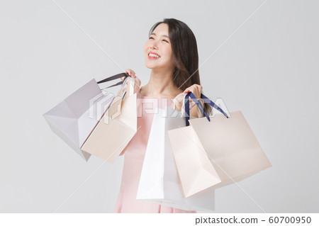 Happy single woman life, an attractive smiling woman holding shopping bags 340 Happy single woman life, an attractive smiling woman holding shopping bags 340 60700950