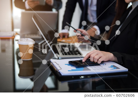 Business documents on office table with smart phone, tablet and laptop computer and graph with social network diagram and two colleagues discussing data in office. 60702606