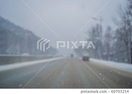Winter road on a snowy day. Focus on the snow Winter road on a snowy day. Focus on the snow 60703254