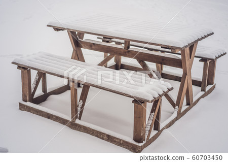 Benches in the winter city park which has been filled up with snow 60703450