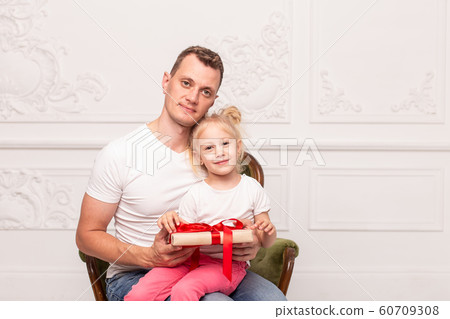 Happy father and his daughter holding gift box and smile. Father's day. Selective focus Happy father and his daughter holding gift box and smile. Father's day. Selective focus 60709308