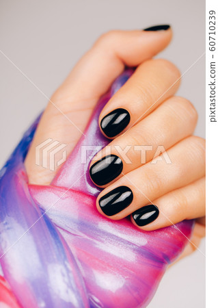 hands with black manicure holding slime hands with black manicure holding slime 60710239