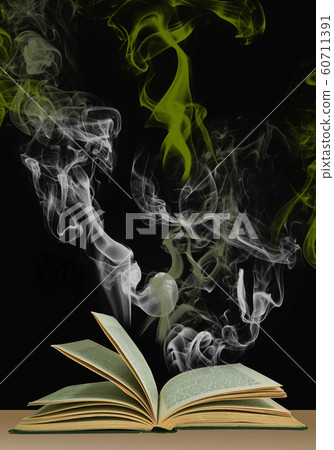 Opened magic book with mystic smoke above it 60711391