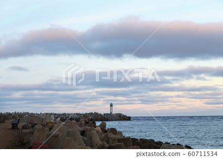 Seascape at sunrise with a lighthouse in the Seascape at sunrise with a lighthouse in the 60711534
