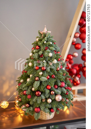 Beautiful small Christmas tree on wooden table. Happy mood. Garland lamp bokeh on background. Wallpaper. Danish pine and fir, Nobilis 60713763
