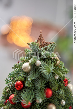 Beautiful small Christmas tree on wooden table. Happy mood. Garland lamp bokeh on background. Wallpaper. Danish pine and fir, Nobilis 60713885