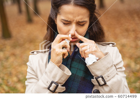 Sick young brunette woman dropping her nose Sick young brunette woman dropping her nose 60714499