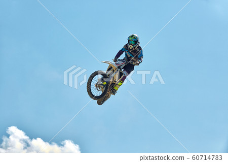 Extreme sports, motorcycle jumping. Motorcyclist makes an extreme jump against the sky. Film grain effect, illumination Extreme sports, motorcycle jumping. Motorcyclist makes an extreme jump against the sky. Film grain effect, illumination 60714783