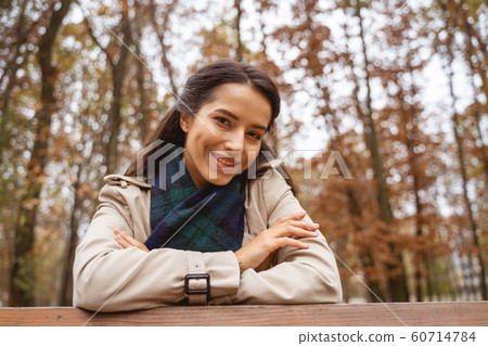 Beautiful young female leaning on the bench 60714784