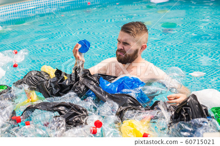 Ecology, plastic trash, environmental emergency and water pollution - shocked man swim in a dirty swimming pool Ecology, plastic trash, environmental emergency and water pollution - shocked man swim in a dirty swimming pool 60715021