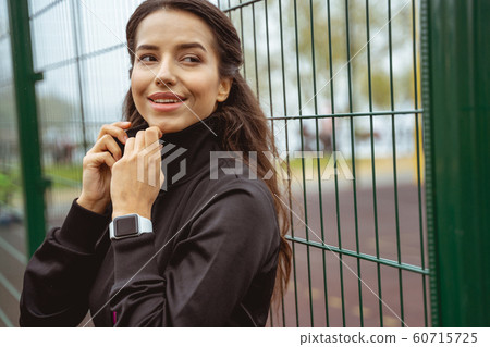 Charming young woman standing on the foreground Charming young woman standing on the foreground 60715725
